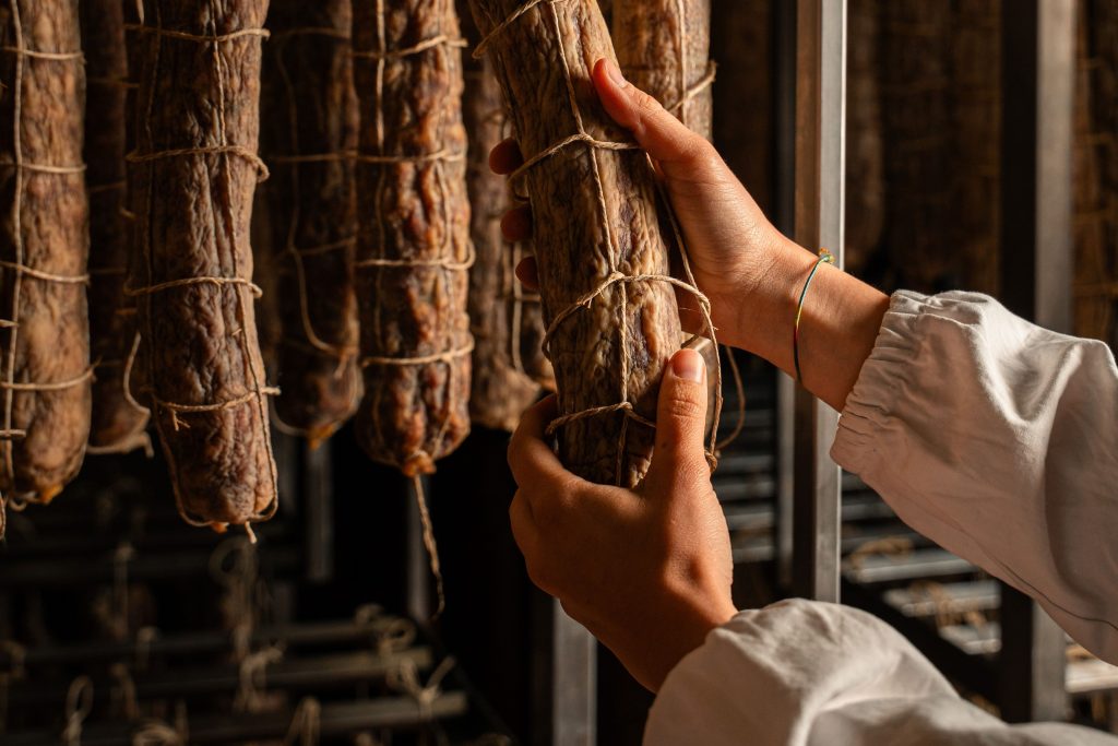 Cosa significa davvero artigianale? Norcino durante la lavorazione artigianale di salumi secondo la tradizione italiana